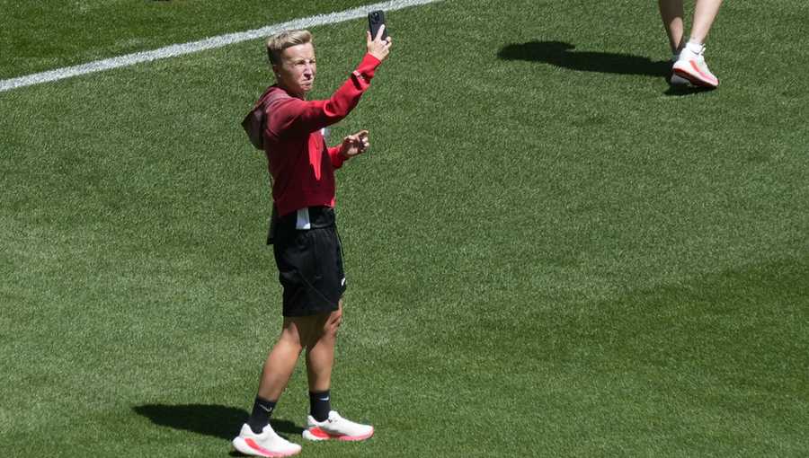 Coach Beverly Priestman of Canada takes photos on the pitch at Geoffroy-Guichard Stadium ahead of the 2024 Summer Olympics, Tuesday, July 23, 2024, in Saint-Etienne, France. Canada is scheduled to play New Zealand on Thursday, July 25. (AP Photo/Silvia Izquierdo)