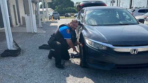 school resource officer changes tire in houma carline