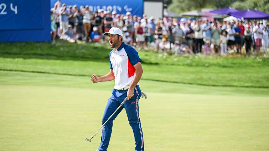 cottie Scheffler of Team USA celebrates with a fist pump after making a birdie putt on the 17th hole green during the final round of the Olympic men's golf competition