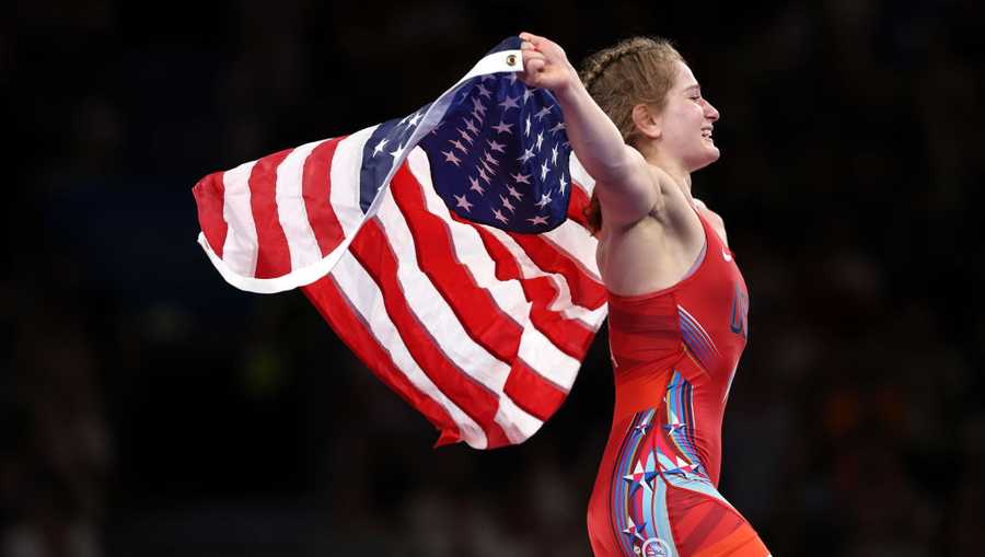 Amit Elor of Team United States celebrates with the United States flag following victory against Meerim Zhumanazarova